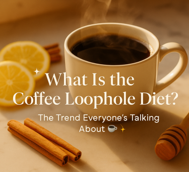 A steaming cup of black coffee on a marble countertop with lemon slices, cinnamon sticks, and honey beside it, illustrating the Coffee Loophole trend.